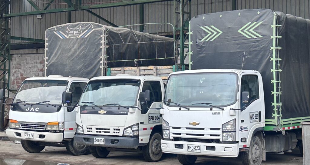Flota de camiones de carga en un centro de reciclaje, listos para el transporte de materiales reciclados. Una parte esencial del Nuevo Mundo del Reciclaje, promoviendo la logística sostenible y la economía circular.