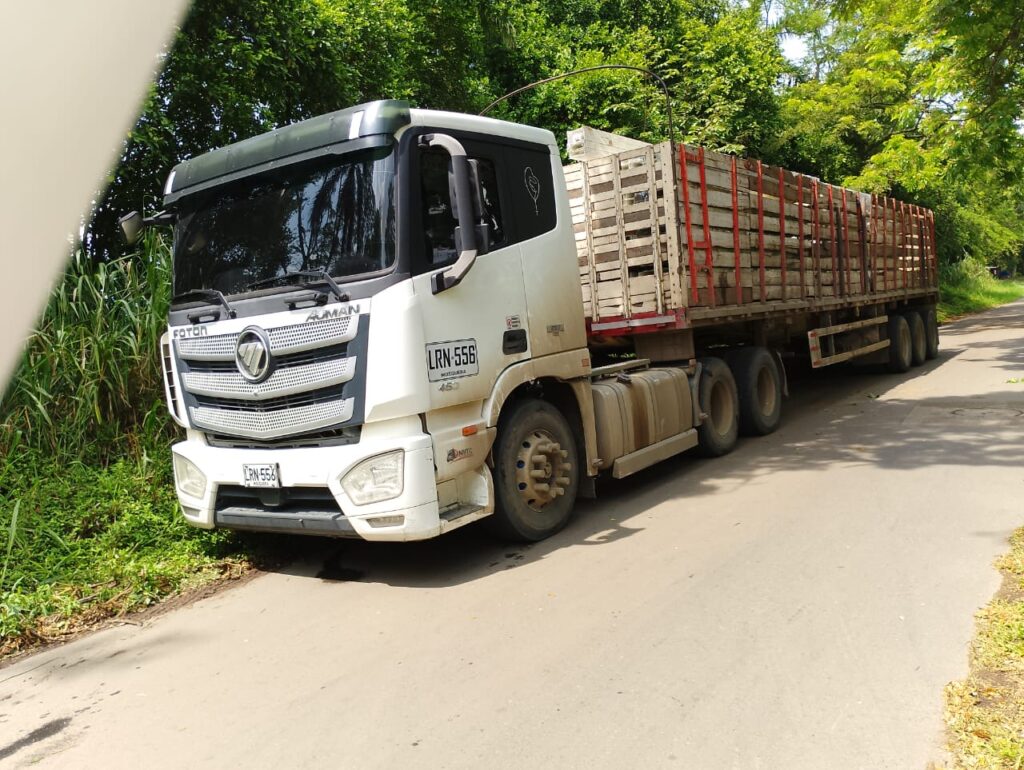 Tracto camión amarillo encendido de noche con luces brillantes, listo para el transporte de materiales reciclables. Un pilar fundamental en la logística del Nuevo Mundo del Reciclaje, impulsando una movilidad sostenible y eficiente.